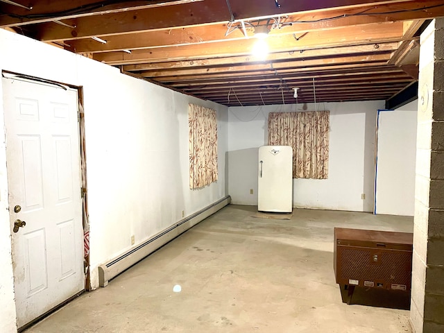 basement featuring a baseboard radiator and fridge