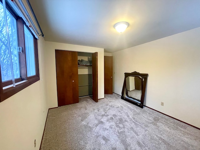 unfurnished bedroom featuring light carpet and a closet