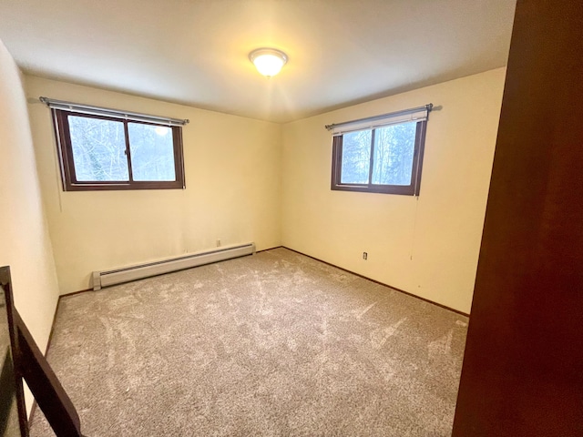 carpeted spare room featuring baseboard heating