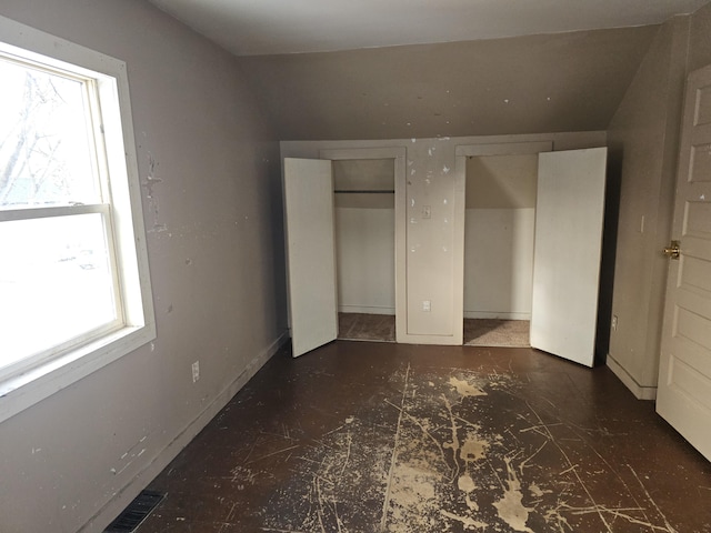 unfurnished bedroom featuring lofted ceiling