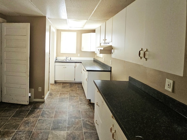kitchen with white cabinetry, sink, and a paneled ceiling