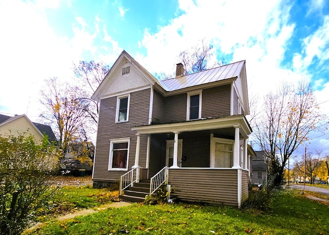 view of front of property with a front yard and covered porch