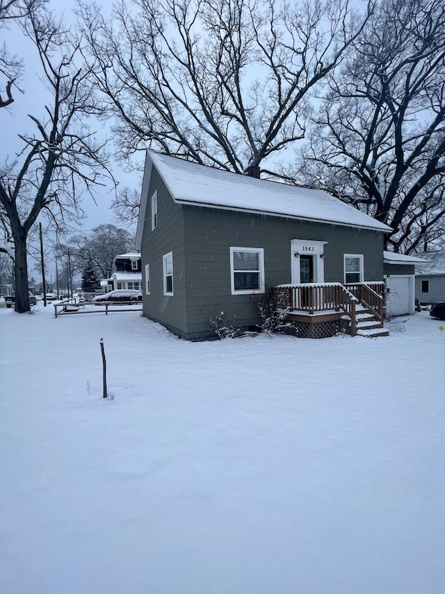 snow covered rear of property featuring a wooden deck