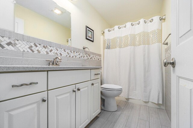 500 Myrtle Ave, Sturgis, MI 49091 - bathroom featuring toilet, vanity, tile walls, curtained shower, and wood finished floors