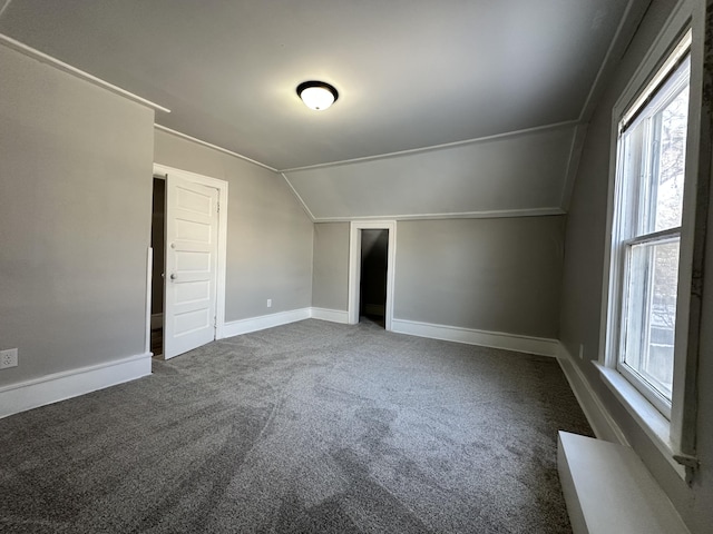 bonus room featuring dark carpet and vaulted ceiling