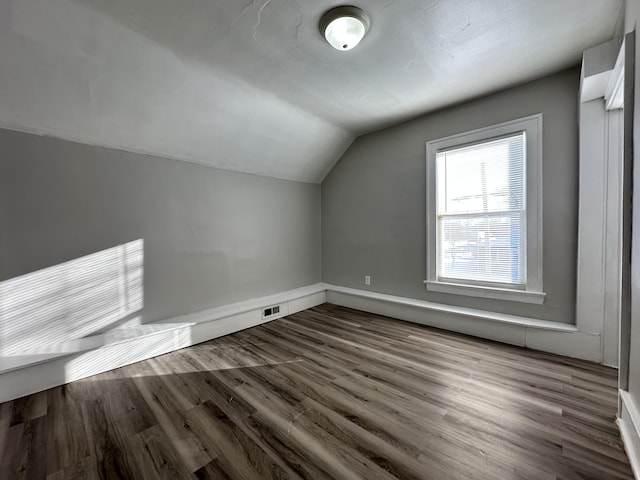 bonus room featuring dark hardwood / wood-style flooring and lofted ceiling