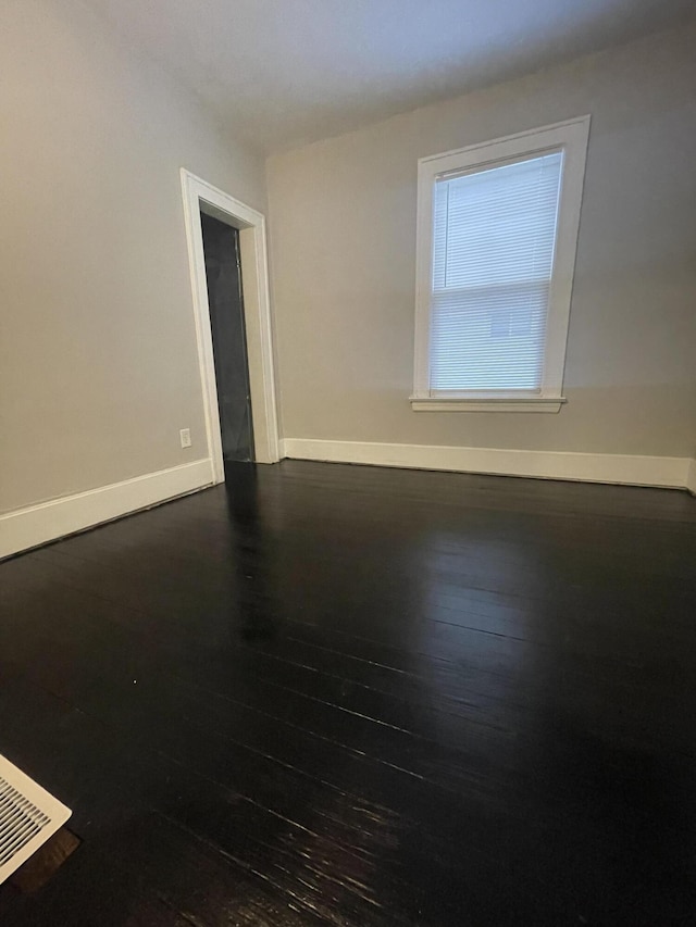 unfurnished room featuring dark wood-type flooring