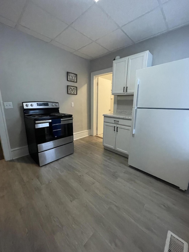 kitchen with white cabinets, a paneled ceiling, white refrigerator, and stainless steel range with electric cooktop