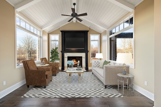 interior space with ceiling fan, lofted ceiling with beams, dark hardwood / wood-style flooring, and a fireplace