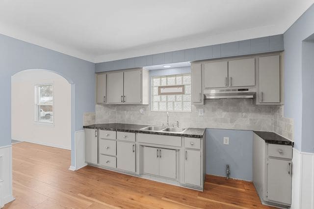 kitchen featuring backsplash, gray cabinets, and sink