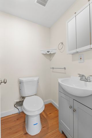 bathroom featuring wood-type flooring, vanity, and toilet