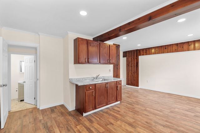 kitchen with hardwood / wood-style floors, ornamental molding, and sink