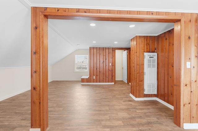 bonus room featuring light hardwood / wood-style flooring, lofted ceiling, and wood walls