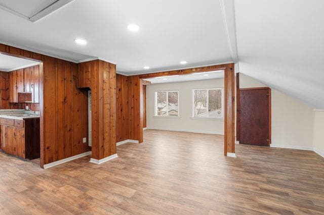 interior space featuring light hardwood / wood-style floors, sink, and vaulted ceiling