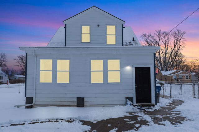 view of snow covered back of property