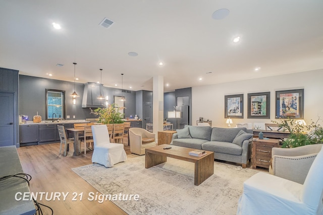 living room with sink and light hardwood / wood-style floors