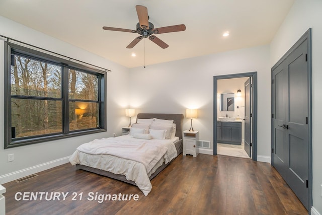 bedroom with ceiling fan, sink, ensuite bathroom, and dark wood-type flooring