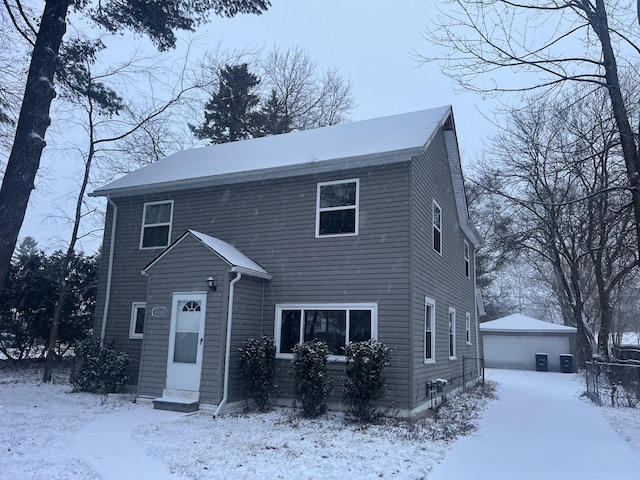 view of front of house featuring a garage and an outbuilding