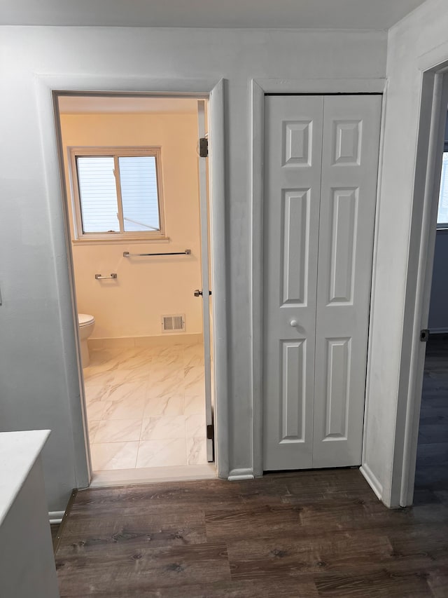 hallway featuring visible vents, marble finish floor, and baseboards