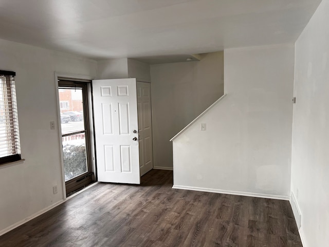 foyer entrance with baseboards and dark wood-style flooring