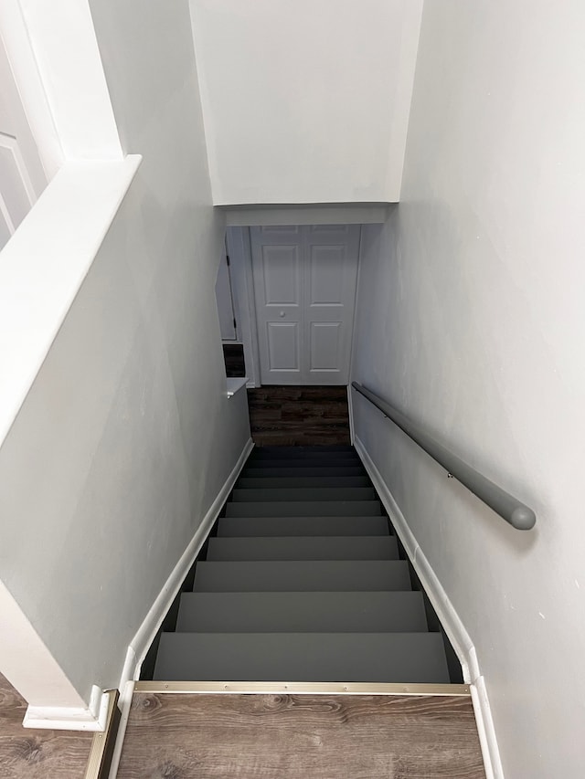 stairway with baseboards and wood finished floors