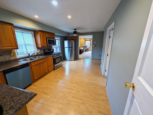 kitchen with a healthy amount of sunlight, stainless steel appliances, light hardwood / wood-style floors, and sink