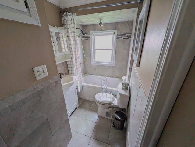 full bathroom featuring tile patterned floors, shower / bath combination with curtain, sink, toilet, and tile walls