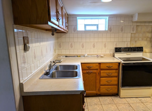 kitchen with backsplash, light tile patterned flooring, electric stove, and sink