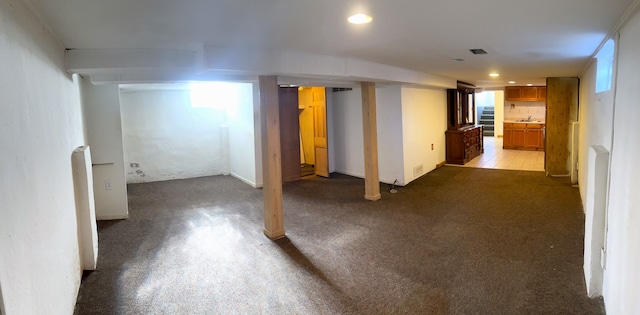 basement featuring light carpet and sink