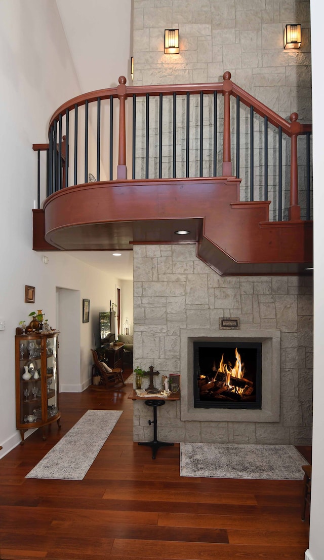 living room with a stone fireplace and hardwood / wood-style floors