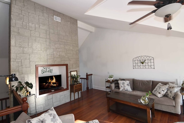 living room featuring a fireplace, dark hardwood / wood-style floors, vaulted ceiling, and ceiling fan