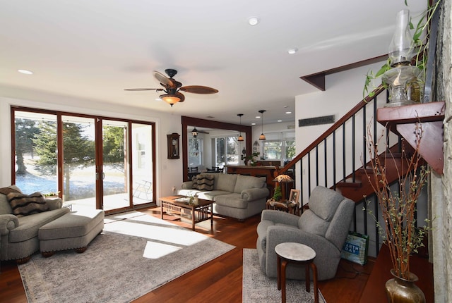 living room with ceiling fan and dark hardwood / wood-style flooring