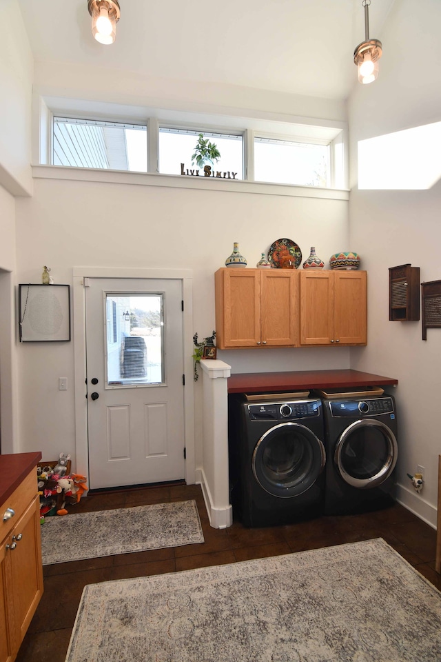 laundry room featuring a healthy amount of sunlight, independent washer and dryer, and a towering ceiling