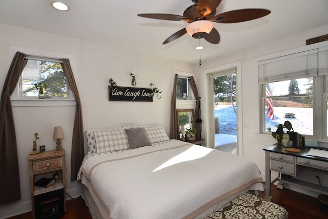 bedroom featuring access to exterior, multiple windows, dark hardwood / wood-style floors, and ceiling fan