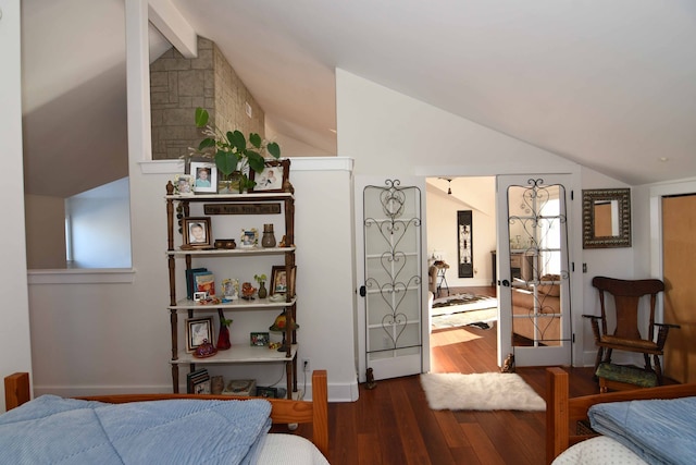 bedroom with lofted ceiling with beams, hardwood / wood-style flooring, and multiple windows