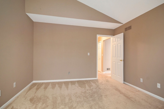 unfurnished room with lofted ceiling and light carpet