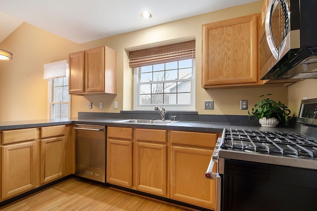 kitchen with sink, stainless steel appliances, and light wood-type flooring