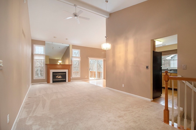 living room featuring beamed ceiling, high vaulted ceiling, ceiling fan, and light carpet