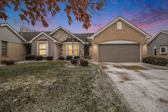 ranch-style house featuring a garage and a yard