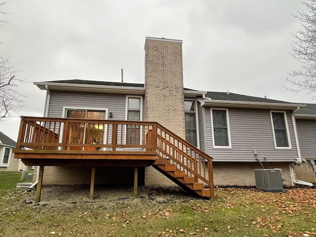 back of property with central air condition unit, a yard, and a wooden deck