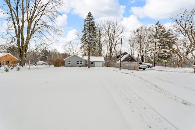 yard covered in snow featuring a garage