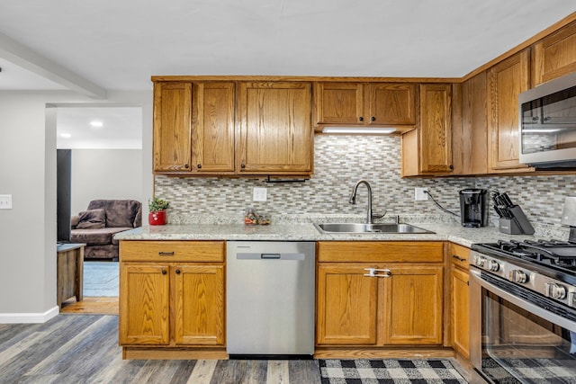 kitchen featuring hardwood / wood-style floors, decorative backsplash, sink, and stainless steel appliances