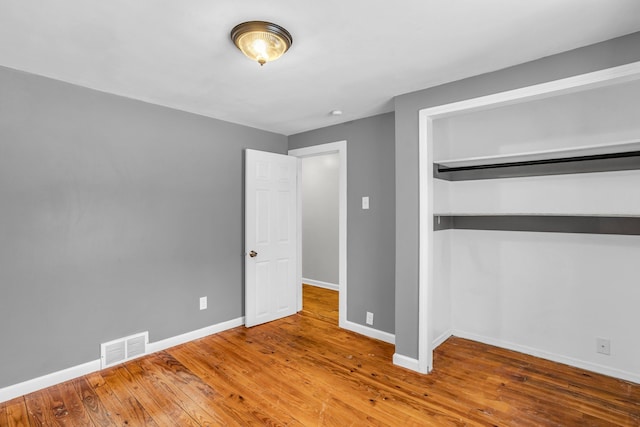 unfurnished bedroom with hardwood / wood-style flooring and a closet