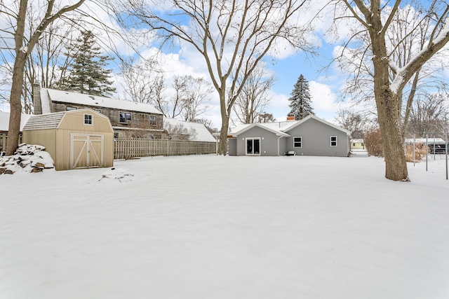 yard layered in snow with a storage shed