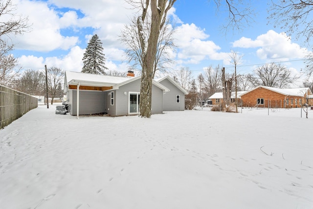 view of snow covered rear of property