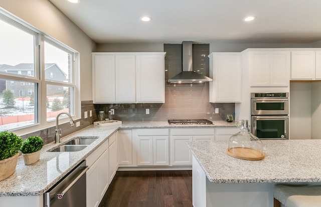 kitchen featuring white cabinetry, appliances with stainless steel finishes, sink, and wall chimney exhaust hood