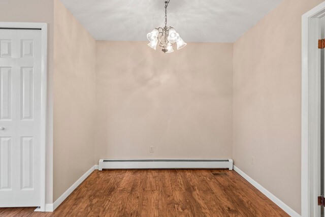 unfurnished dining area with baseboard heating, hardwood / wood-style floors, and a notable chandelier