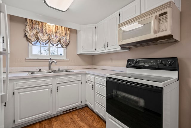 kitchen with sink, white cabinets, electric range oven, and light hardwood / wood-style floors