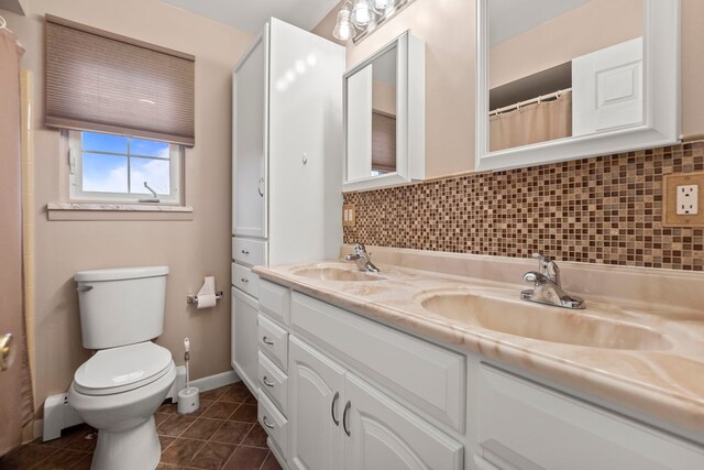 bathroom with vanity, toilet, tile patterned floors, and tasteful backsplash