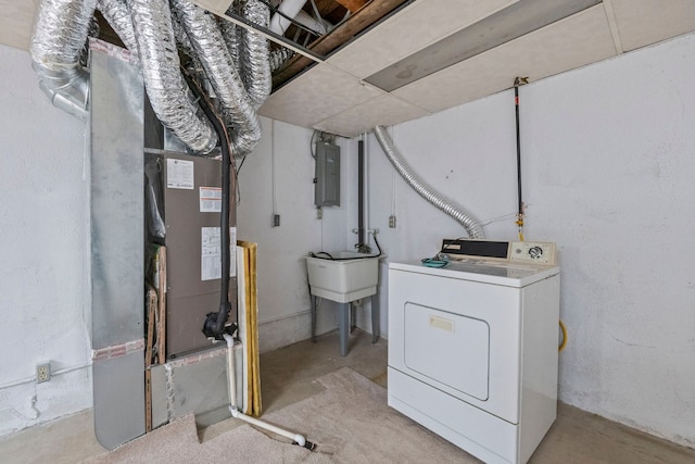 basement featuring heating unit, electric panel, and washer / dryer